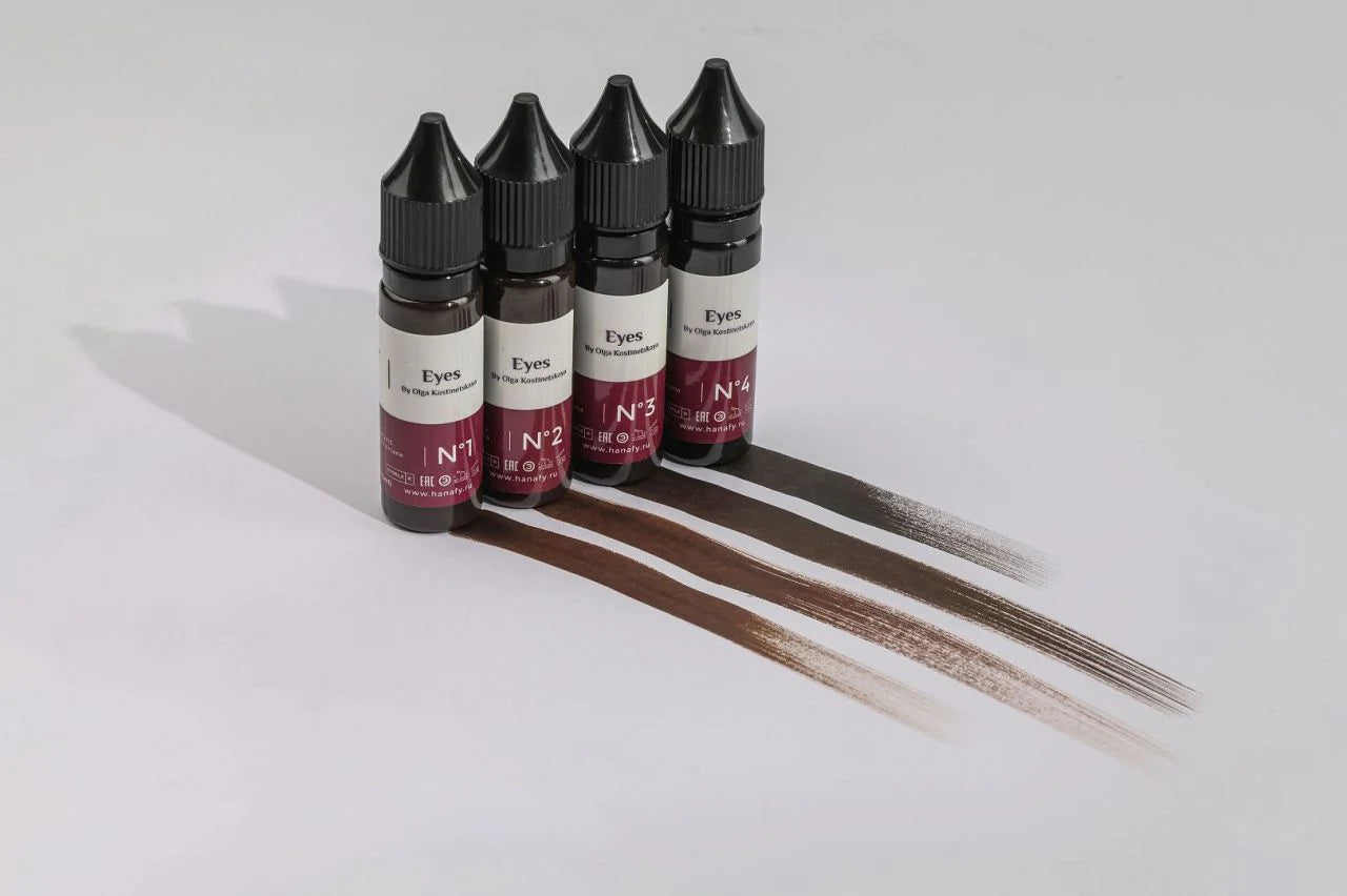 Five bottles of hair dye with color samples on a white background