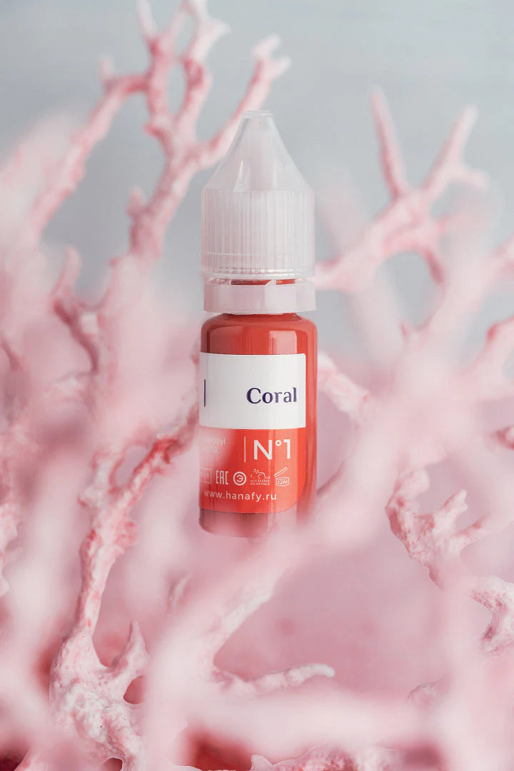 Red bottle labeled 'Coral' with a white cap on pink coral background
