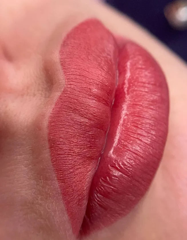 Close-up of a person's red lipstick on lips with a blurred background